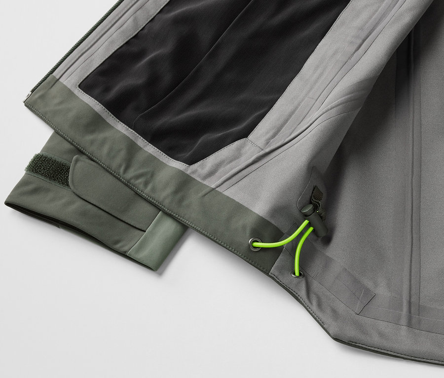Detailansicht einer grauen 3-Lagen-Outdoorjacke mit grünen Akzenten.