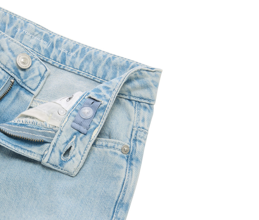 Nahaufnahme von hellblauen Jeans mit weitem Bein und verstellbarem Bund.