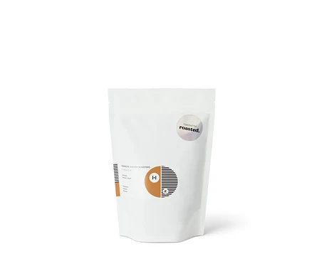 Ein weißer Beutel „Hermetic x roasted. Co-Roast #1 Espresso - 250 g Ganze Bohne“
