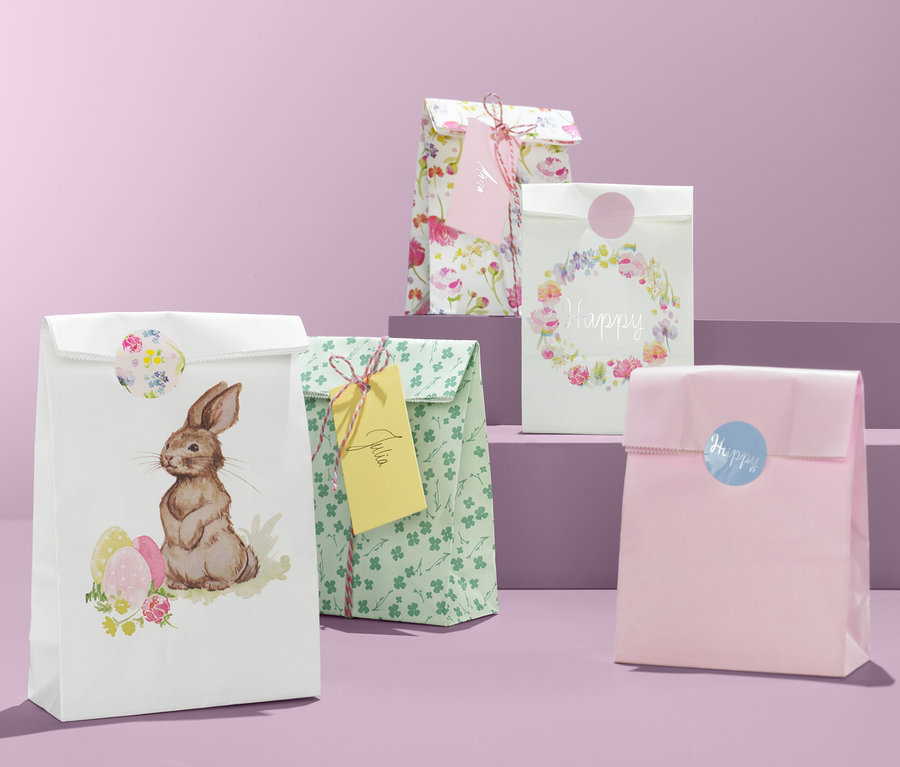 Vier Geschenktüten-Set mit Ostermotiven auf lila Hintergrund.