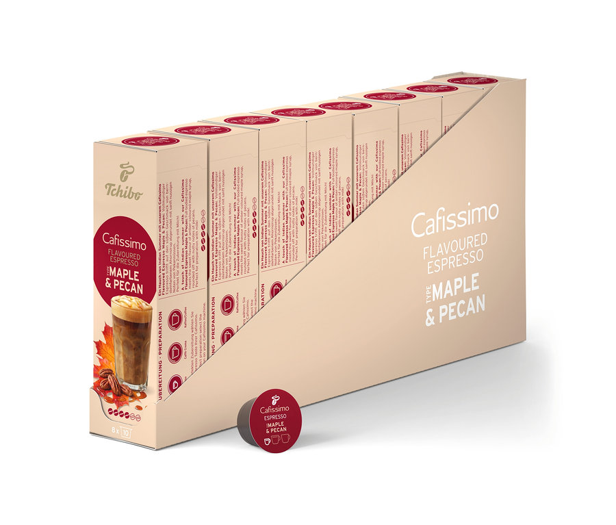 Eine beige Displaybox enthält 80 Cafissimo Flavoured Espresso - Maple & Pecan Kaffeekapseln. Die vordere Packung zeigt ein Kaffeegetränk mit Ahornblättern und Pekannüssen, und eine einzelne dunkelrote Kapsel liegt davor.