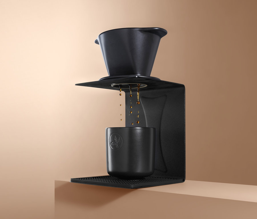 Schwarzer Handfilter-Halter mit Tasse auf beigem Hintergrund.