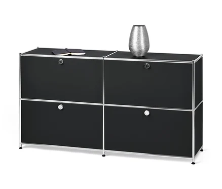 Schwarzes Sideboard »CN3« mit vier Klappen. Oben liegen ein Notizbuch und eine silberne Vase.