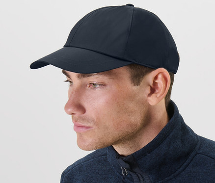 Mann trägt eine blaue Allwetter-Kappe und eine blaue Jacke.