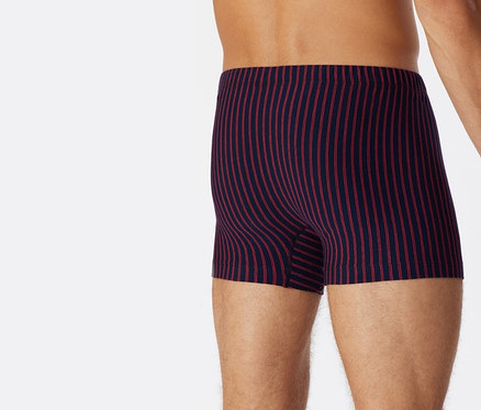 Mann von hinten trägt rote SCHIESSER Shorts mit Bio-Baumwolle.