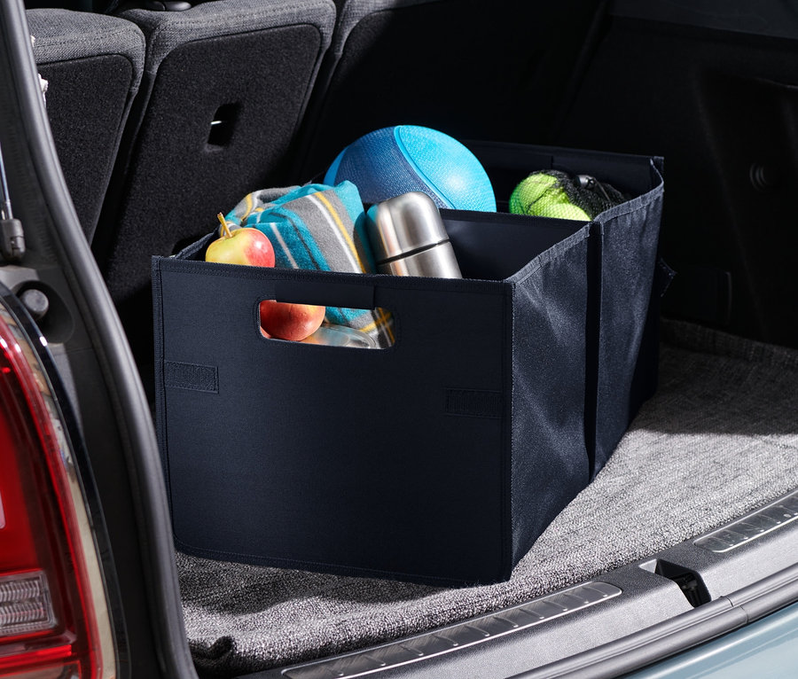 Eine Auto-Faltbox liegt im Kofferraum eines Autos. In der Box liegen eine Decke, ein Ball und eine Thermoskanne.