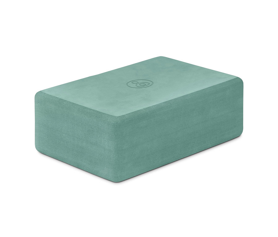 Ein grüner Yoga-Block auf einem weißen Hintergrund.