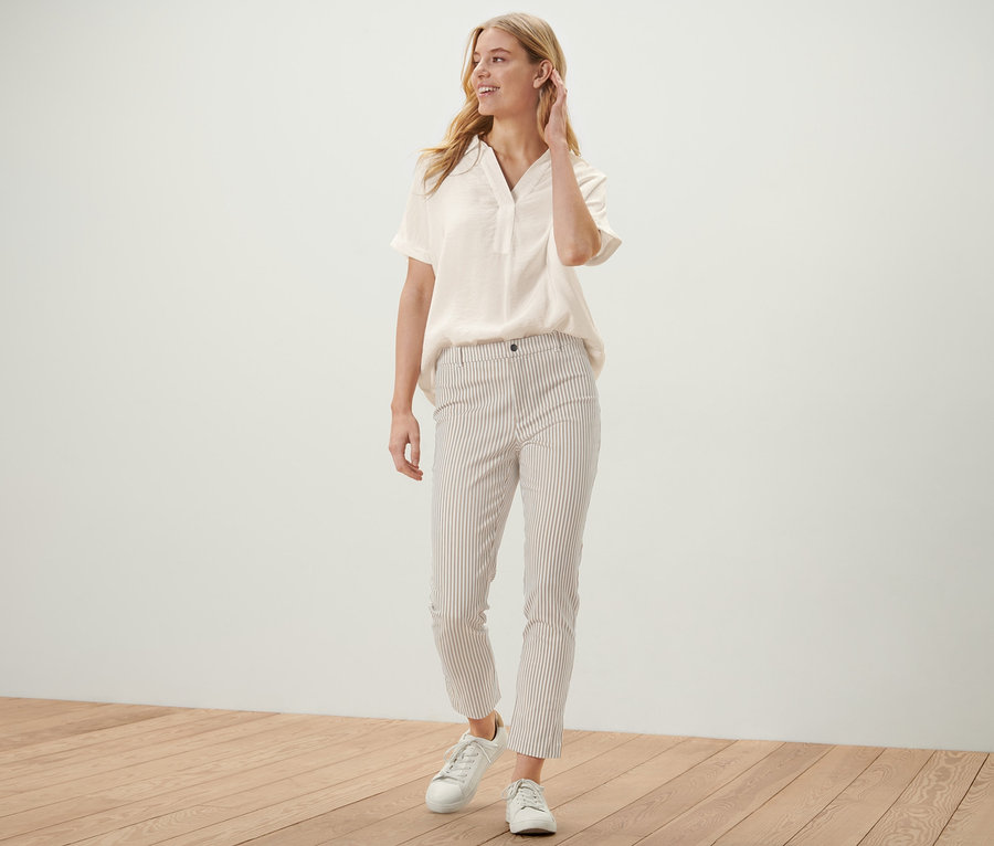 Frau posiert in hellblauer Bluse und einer gestreiften Stretch-Twill-Hose.