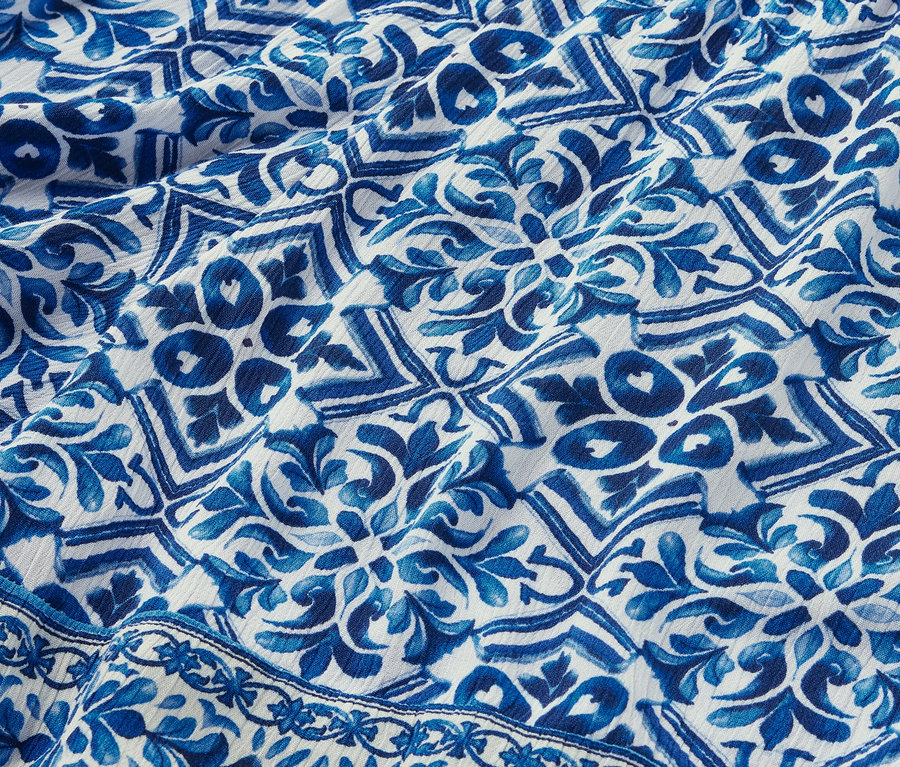 Detailansicht von bedruckten Webshorts mit blau-weißem Muster.