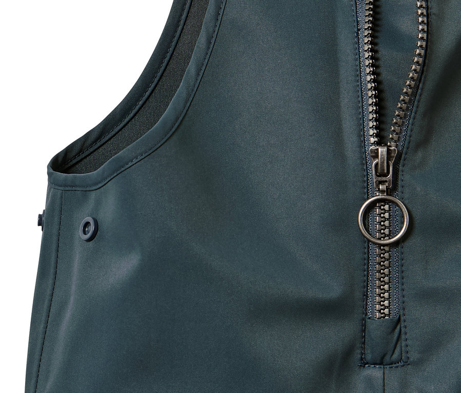 Detail einer Kleinkind-Regenhose mit Reißverschluss und Knopf.