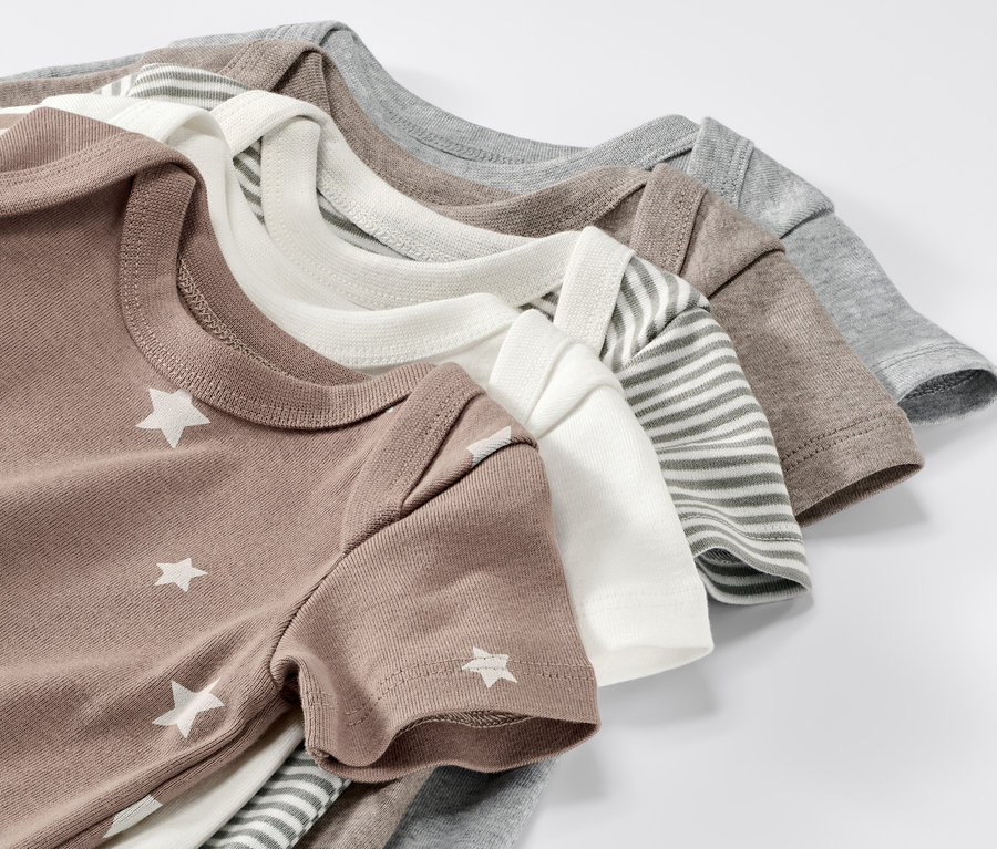 Detailaufnahme von fünf kurzärmeligen Babybodys in Braun, Weiß, Grau und gestreift.