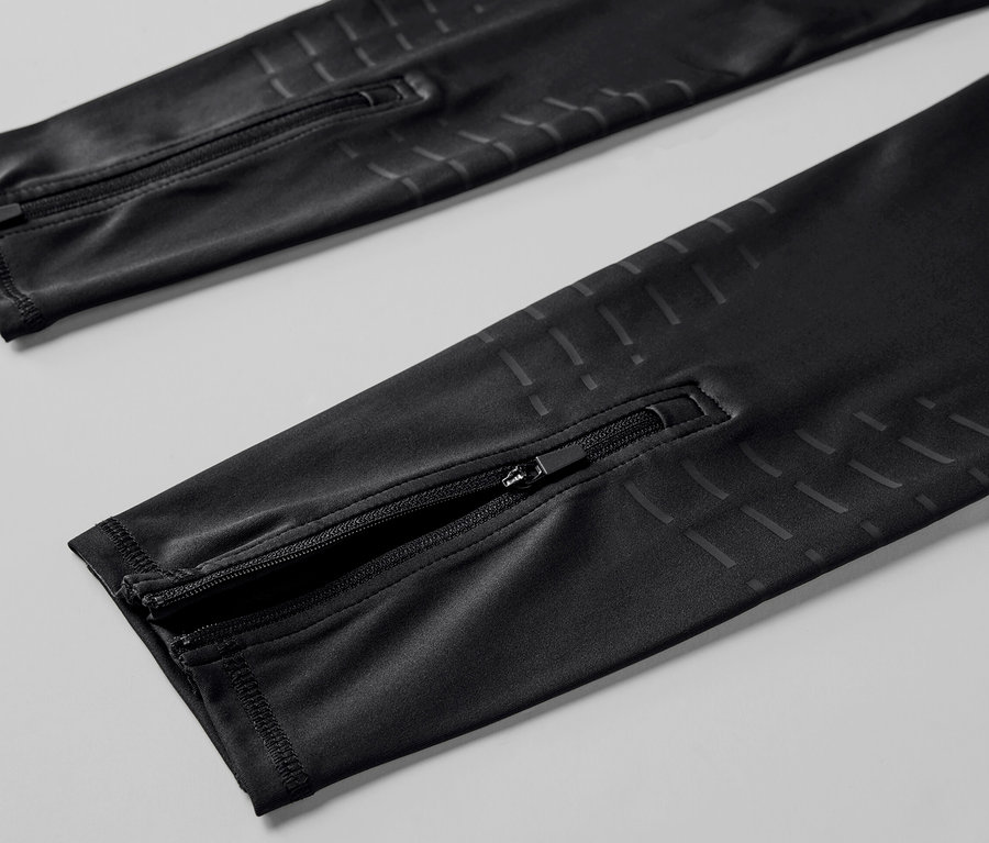 Detailansicht einer schwarzen Lauftight mit Reissverschlüssen an den Beinenden.