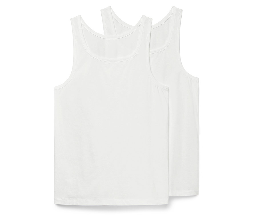 Zwei weiße Tanktops liegen übereinander.