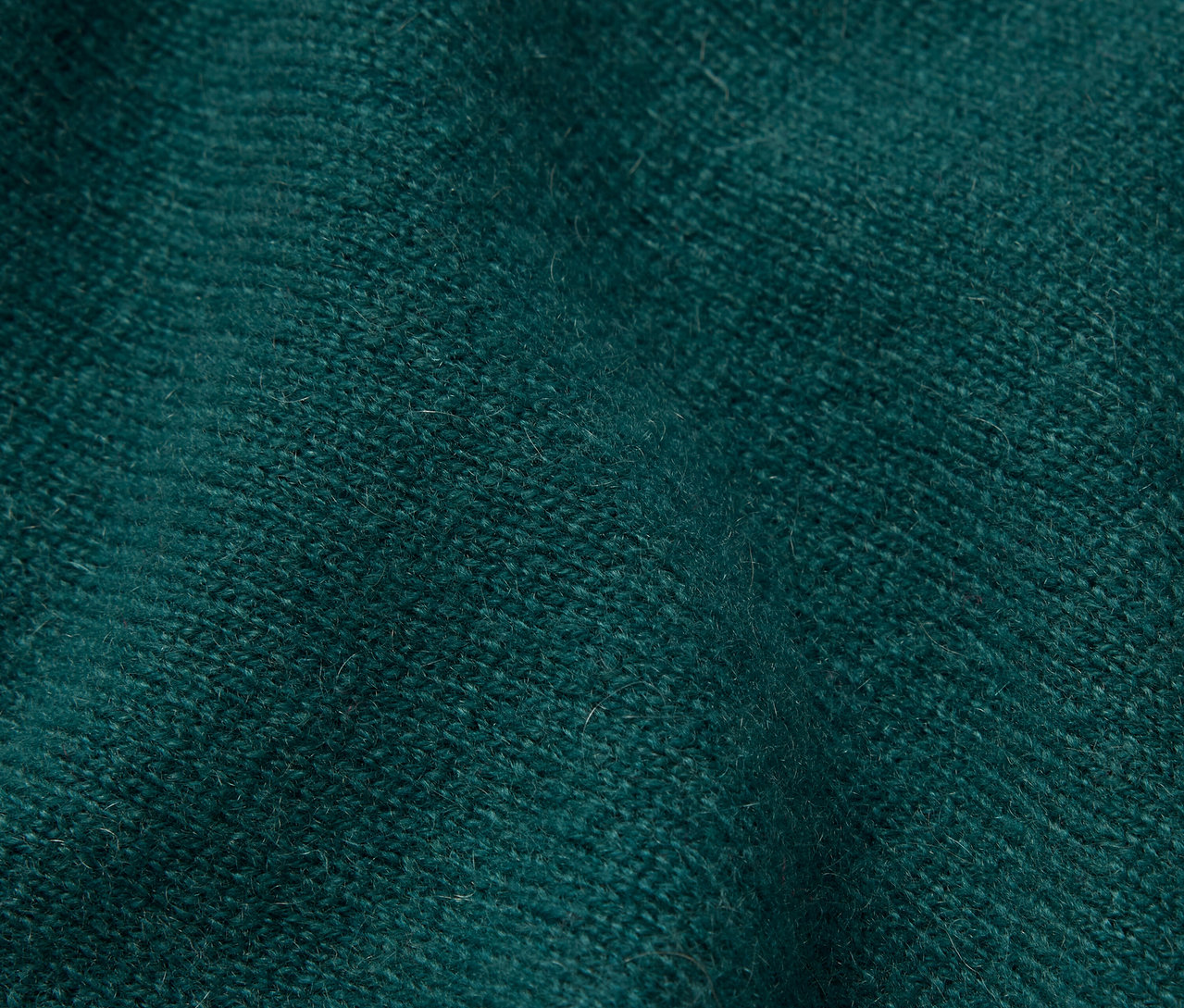 Nahaufnahme eines smaragdgrünen, strukturierten Stoffes.