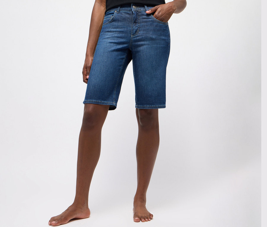 Person trägt Angels Jeans »Bermuda Turn-Up«, Straight Fit, in mittlerem Blau.