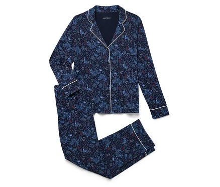 Ein marineblaues Pyjama-Set mit Alloverprint liegt gefaltet auf einem weißen Hintergrund.