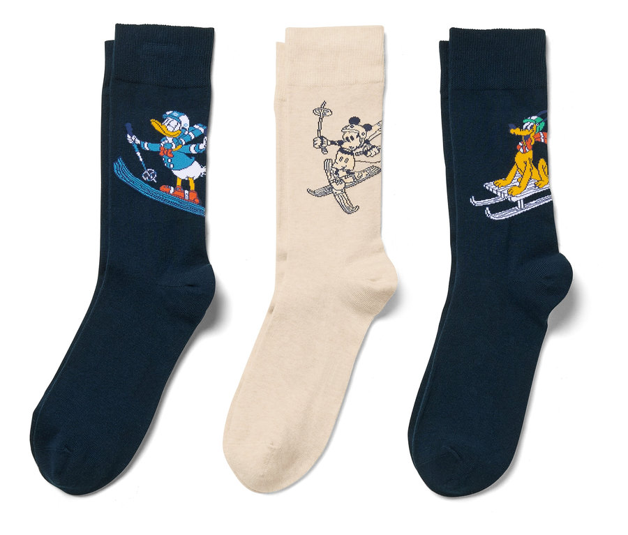 Drei Paar Socken mit Comicfiguren beim Skifahren auf weißem Hintergrund.