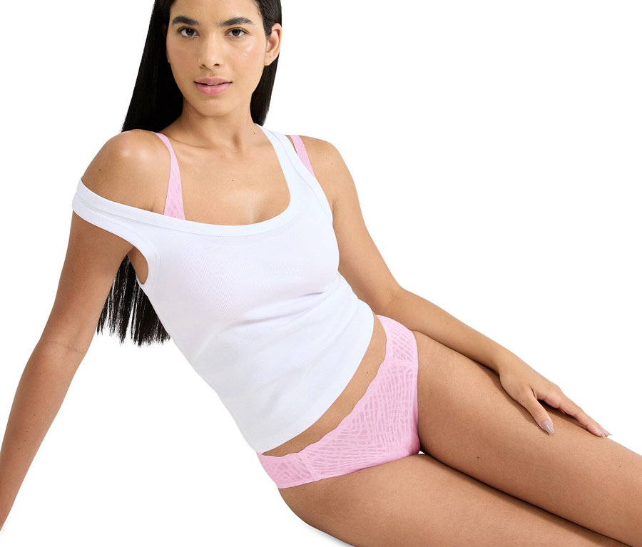 Frau liegt in einem weißen Tanktop und rosa Unterwäsche.