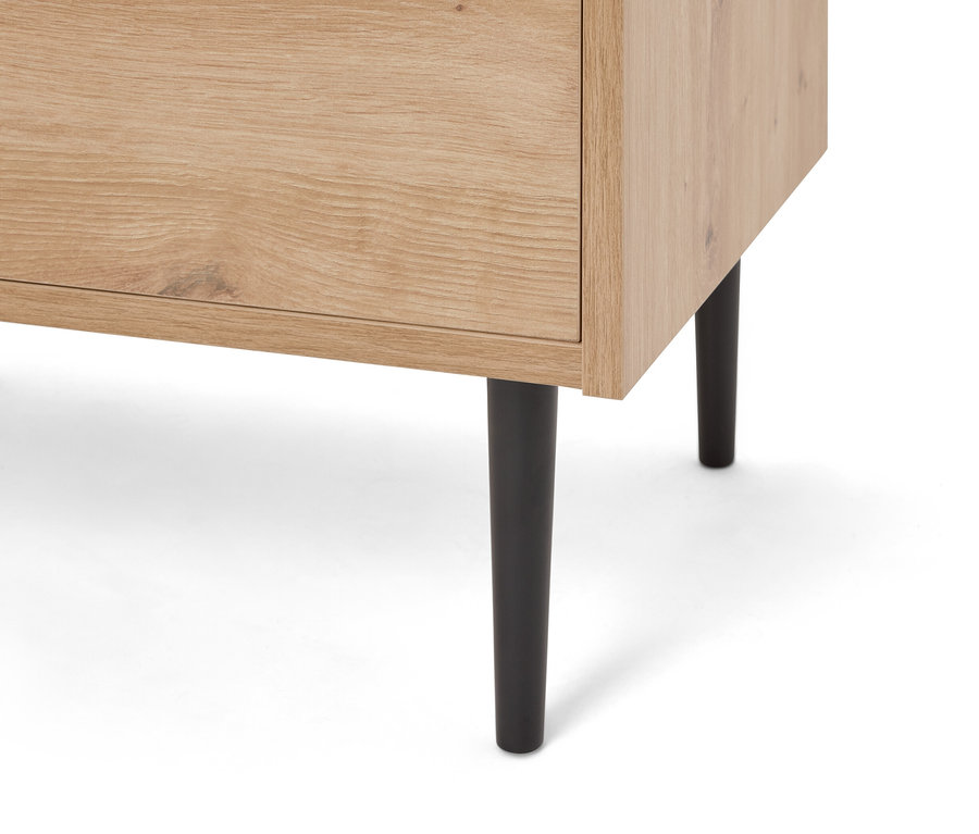 Nahaufnahme eines hellbraunen Holzschranks mit schwarzen Füßen.