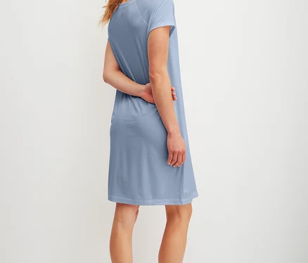 Frau mit blonden Haaren, von hinten gesehen, trägt ein hellblaues T-Shirt-Kleid.