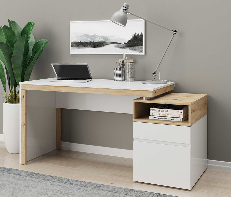 Schreibtisch mit Laptop, Lampe und Büchern vor grauer Wand.