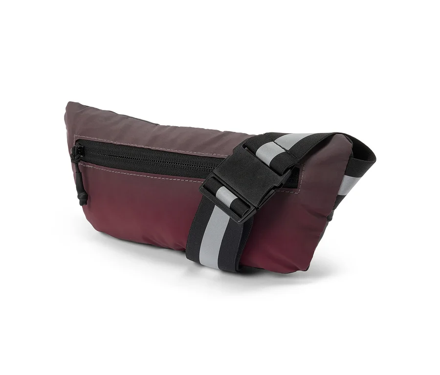 Eine Bauchtasche in Burgunderrot und Dunkelgrau mit Farbverlauf, schwarzem Reißverschluss und schwarzem Riemen mit zwei reflektierenden grauen Streifen und einer schwarzen Schnalle.