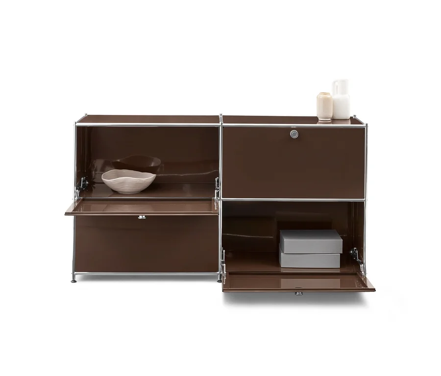 Braunes modulares Sideboard mit Metallrahmen. Links oben eine helle Schale, unten eine offene Klappe. Rechts oben eine geschlossene Tür mit Schloss, darauf zwei Vasen. Unten eine offene Klappe mit zwei grauen Boxen.