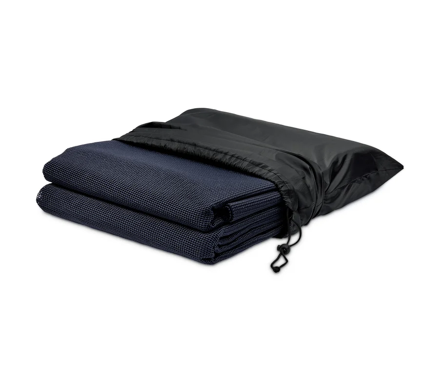 Ein gefalteter Outdoor-Teppich und ein Zeltteppich in einer schwarzen Tasche.