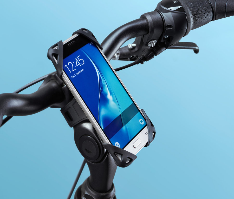 Detailaufnahme eines schwarzen Fahrrads mit einer Fahrrad-Smartphone-Halterung am Lenker, in der sich ein weißes Smartphone befindet.