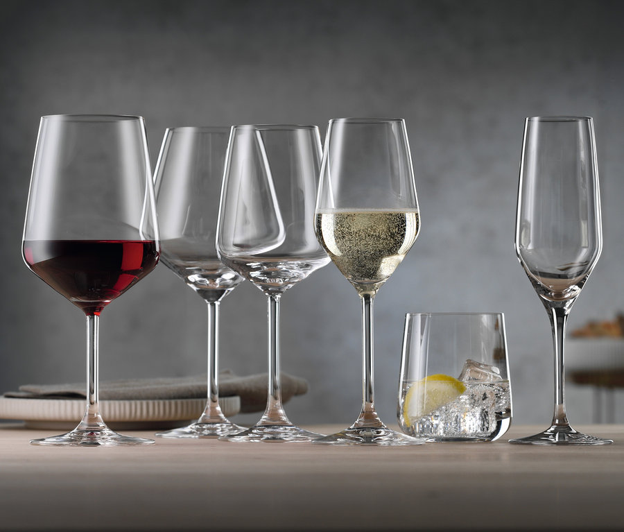 Sechs Gläser stehen auf einem Tisch: ein Rotweinglas gefüllt, zwei leere, ein Sektglas gefüllt, ein Wasserglas mit Zitrone und ein leeres Sektglas. Spiegelau Rotweingläser, Weißweingläser, Champagnergläser und Wassergläser »Style«, jeweils im 8er-Set.