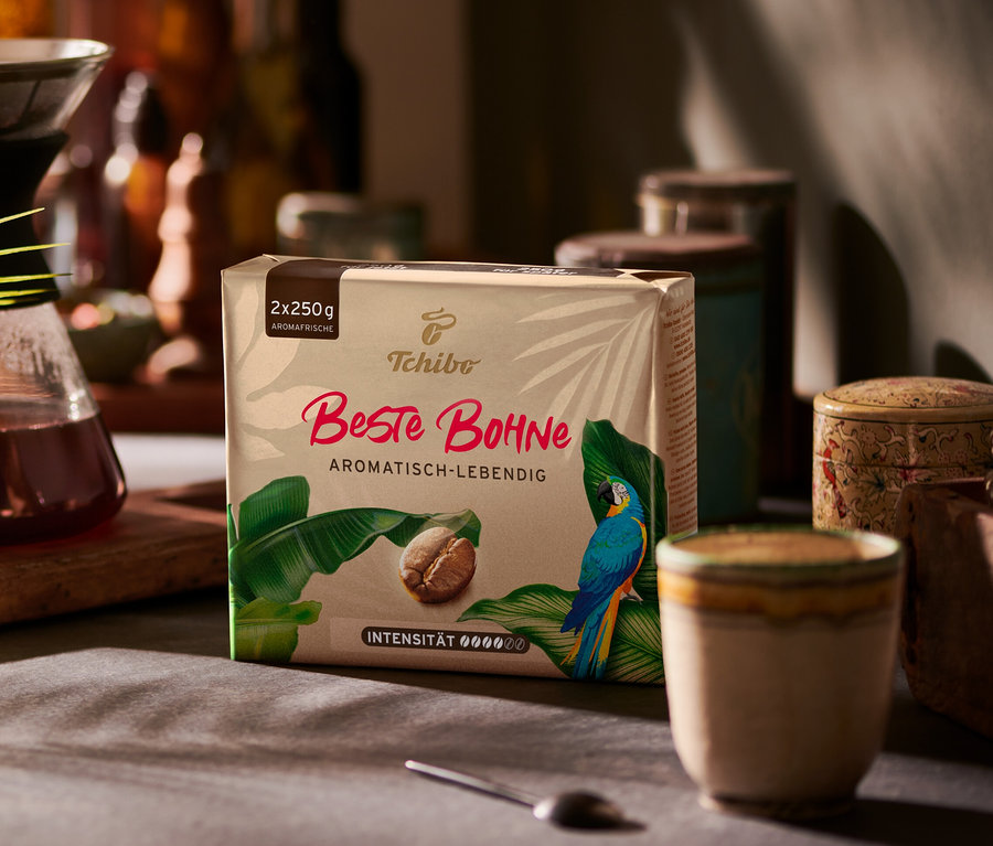 Eine 2x250g Packung Beste Bohne Kaffee steht neben einer Kaffeekaraffe auf einem Tisch.