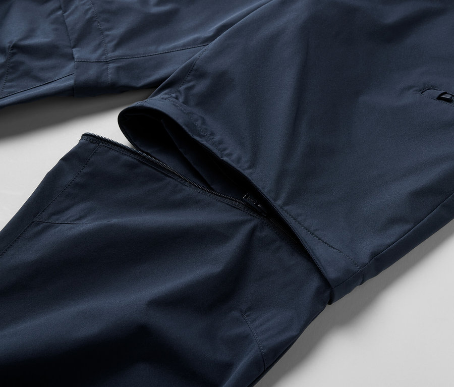 Detailaufnahme einer blauen 2-in-1-Funktionshose mit Reißverschluss.