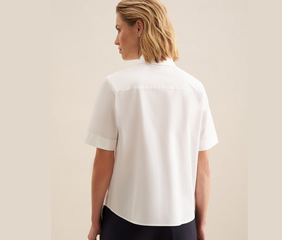 Frau von hinten trägt eine weiße Seidensticker Kurzarm-Bluse.