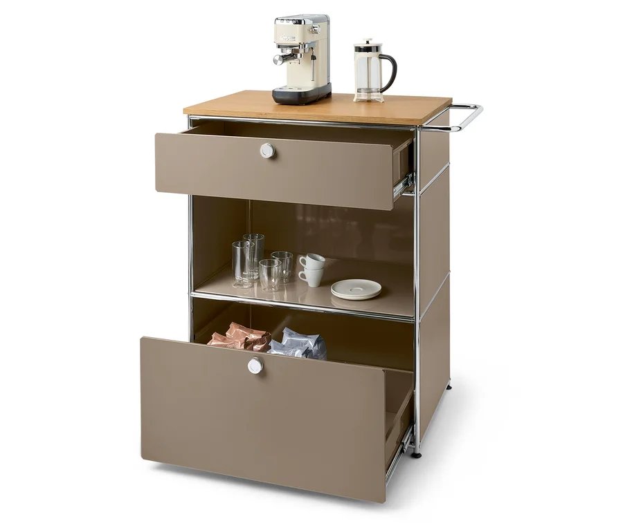 Auf einer braunen Kommode stehen eine Kaffeemaschine und eine French Press. Die untere Schublade ist geöffnet und enthält Kaffeepackungen.