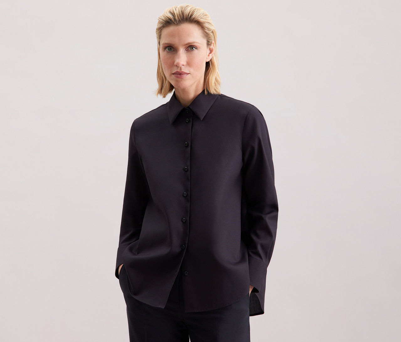 Frau trägt eine dunkelblaue Seidensticker Regular-Bluse.