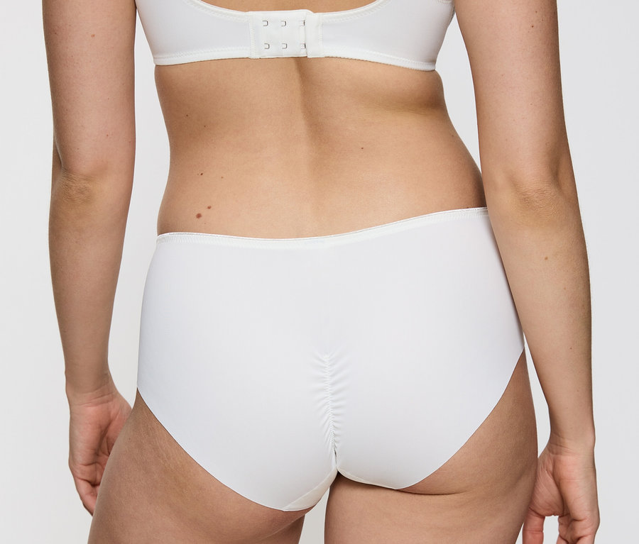 Rückansicht einer Frau, die einen weißen Triumph Essential »Minimizer Hipster X«, Vanille und einen weißen BH trägt.