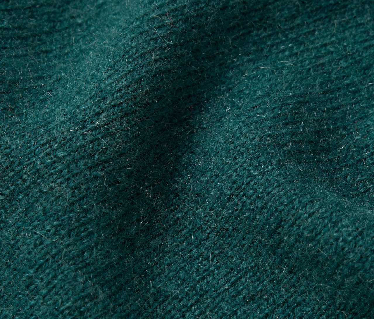 Detailaufnahme einer dunkelgrünen Stricktextur.