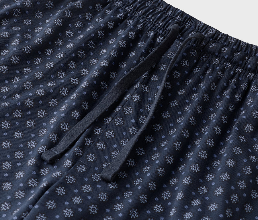 Nahaufnahme einer marineblauen Pyjamahose mit Blumenmuster und Kordelzug.