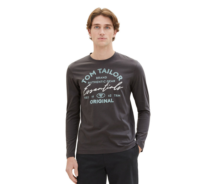 Mann mit Tom Tailor Longsleeve mit Logo, Dark Shadow und schwarzer Hose.