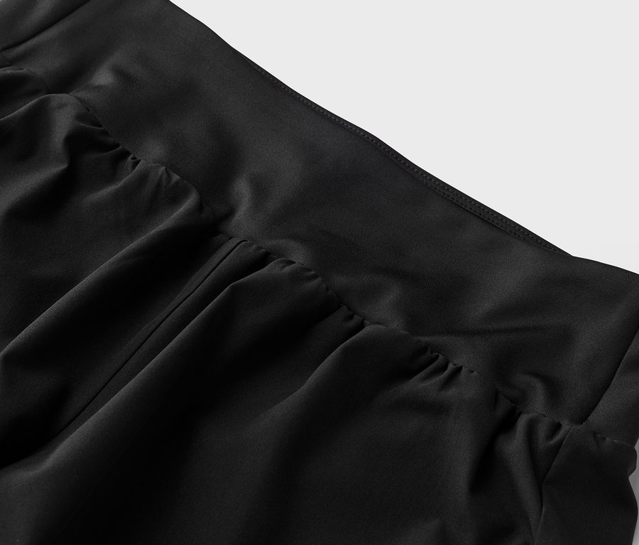 Nahaufnahme von schwarzem Stoff mit Raffdetails am Bund.