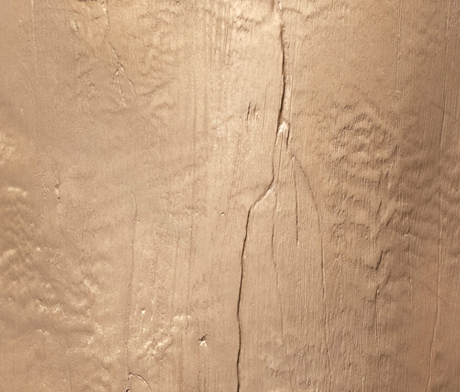 Nahaufnahme einer beigen, strukturierten Wand mit Rissen und Vertiefungen.