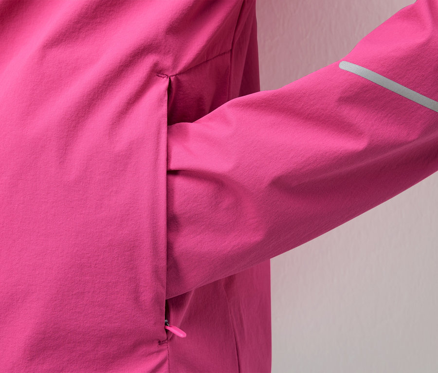Nahaufnahme einer pinkfarbenen Jacke mit einem reflektierenden Streifen am Ärmel.
