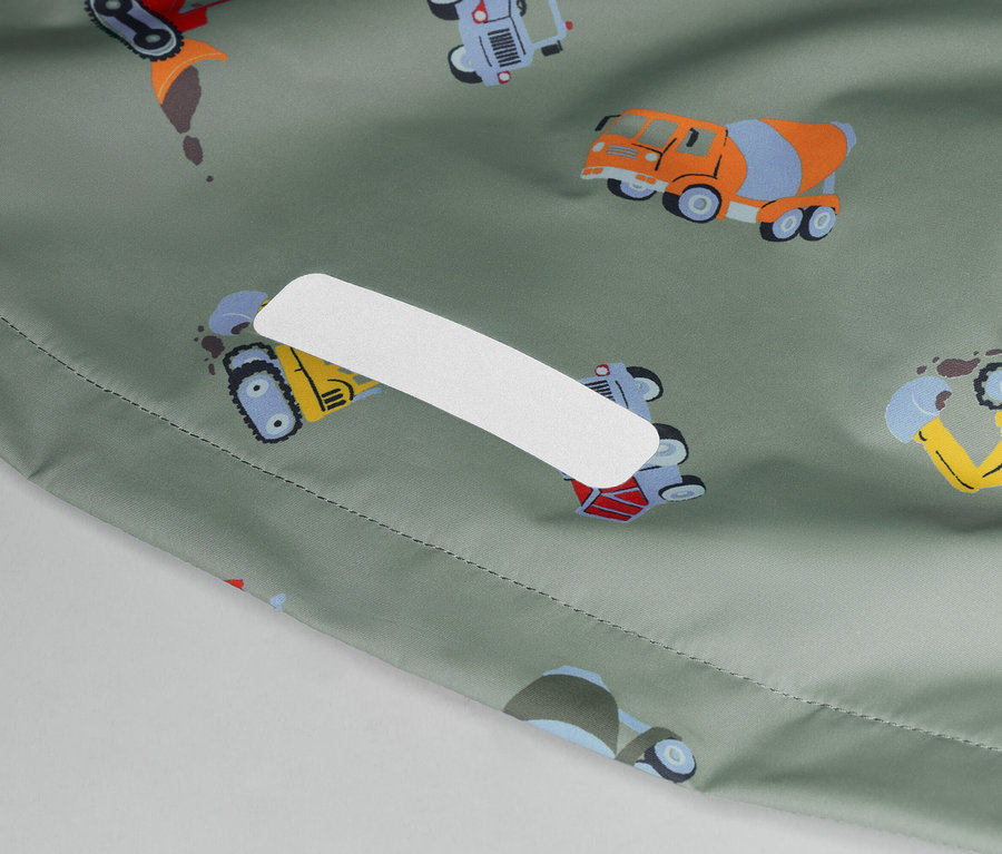 Nahaufnahme eines olivgrünen Stoffes mit bunten Baufahrzeugen und einem weißen Pflaster.