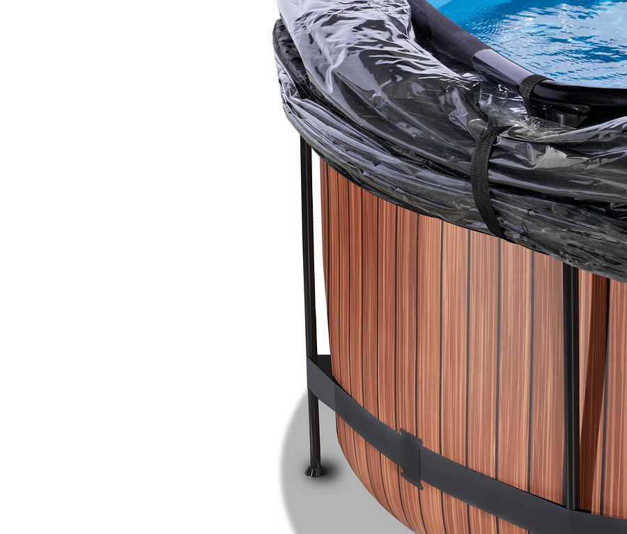 Runder Pool des EXIT Pool-Sets «WOOD» mit Holzoptik-Verkleidung, schwarzen Metallstützen und einer transparenten Abdeckung, unter der blaues Wasser sichtbar ist.