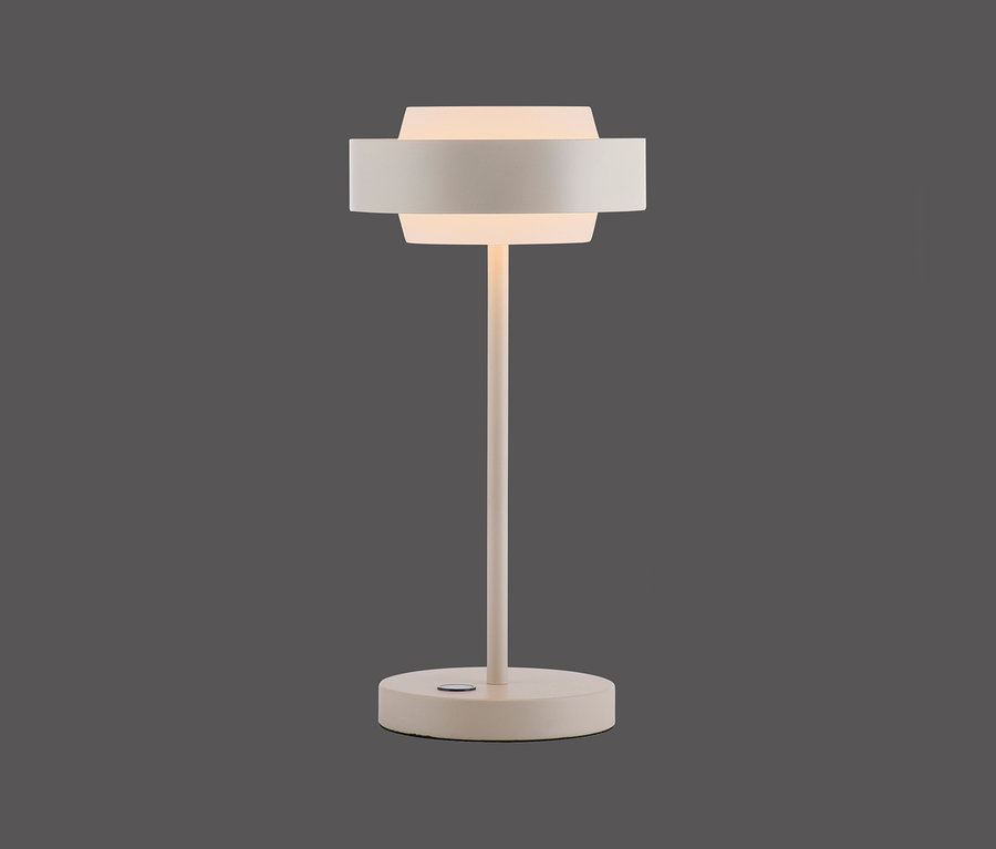 Helle beige moderne Tischlampe mit dünnem Stiel, rundem Fuß und einem geschichteten zylindrischen Schirm, der oben und unten Licht abgibt.