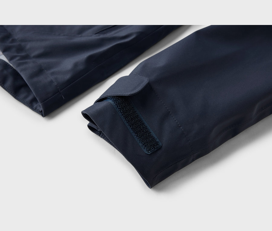 Nahaufnahme eines marineblauen Jackenärmels mit verstellbarem Klettverschluss am Bündchen.