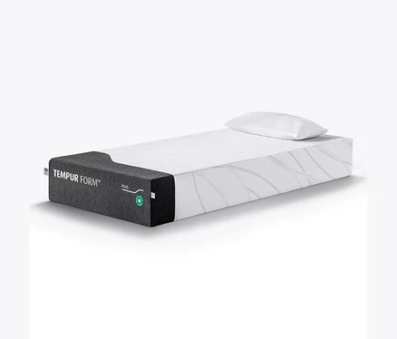 Eine TEMPUR Form™ Plus Matratze, medium, mit einem weißen, gemusterten Kissen darauf.