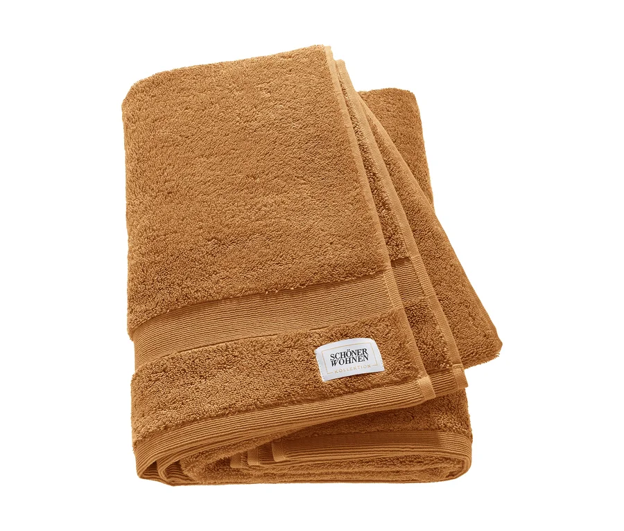 Zwei braune, gefaltete SCHÖNER WOHNEN-Kollektion „Cuddly“ Badetücher mit sichtbarem Label.