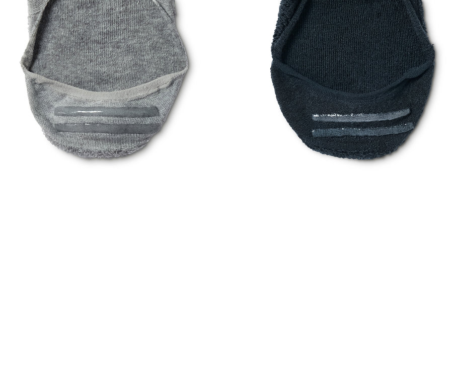 Detailaufnahme von zwei Paar Sport-Füßlingen, einmal grau und einmal dunkelblau.