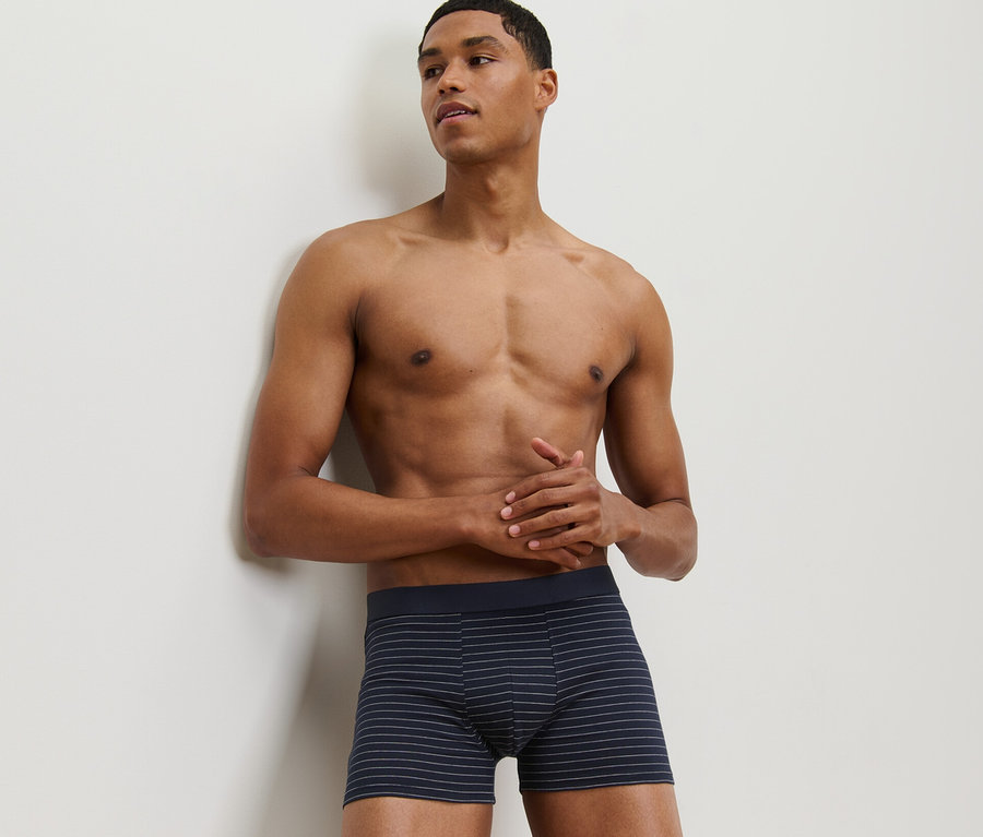 Mann lehnt an Wand und trägt eine von 2 Slipboxern.